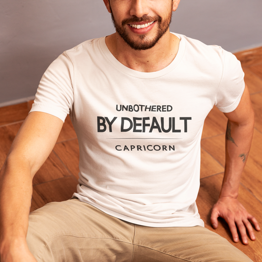 Model wearing Capricorn zodiac t-shirt with “Unbothered by Default” typography quote design