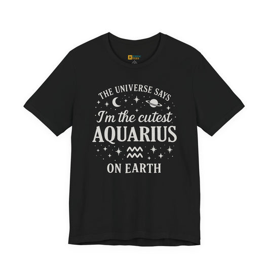 A black T-shirt featuring a white Aquarius zodiac typography design that reads “The Universe Says I’m the Cutest Aquarius on Earth,” with stars, a crescent moon, a planet and the Aquarius zodiac symbol.