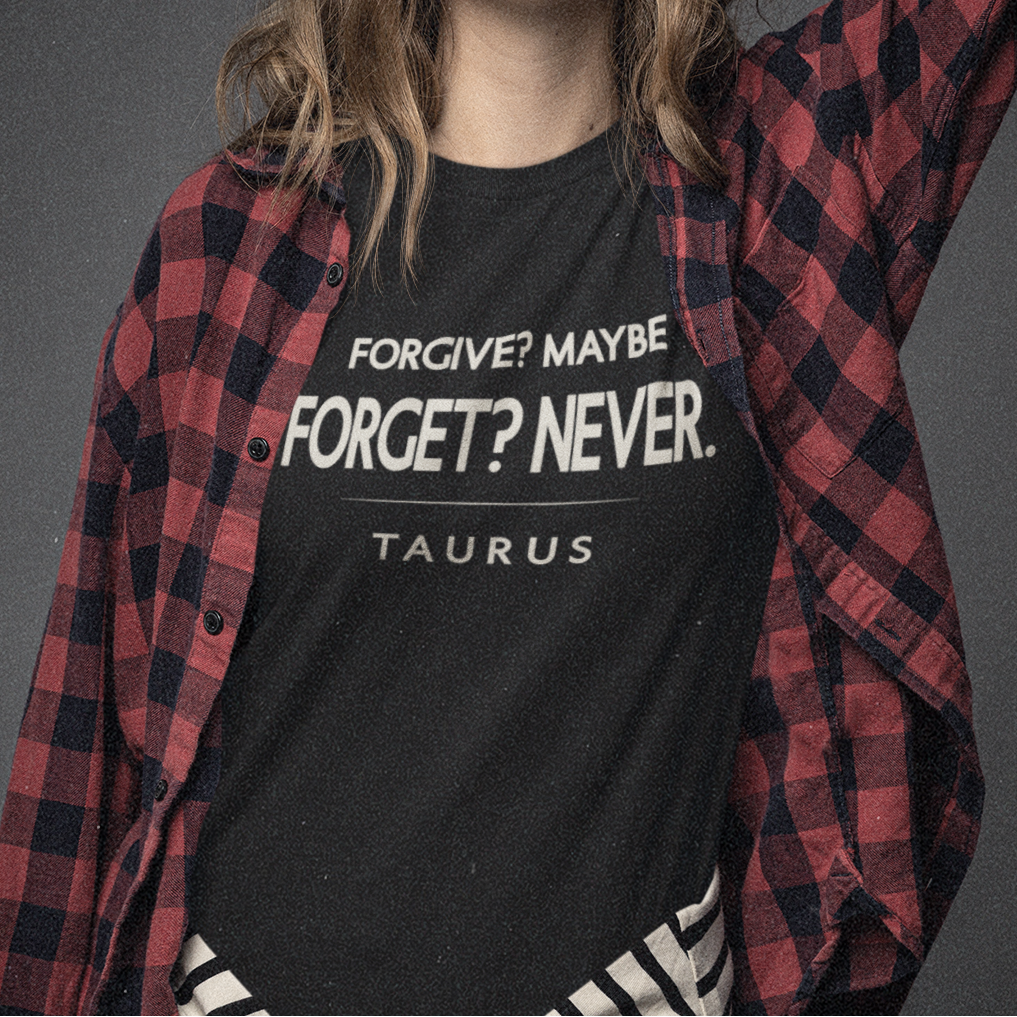Model wearing Taurus zodiac t-shirt with “Forgive? Maybe. Forget? Never.” bold typography quote design