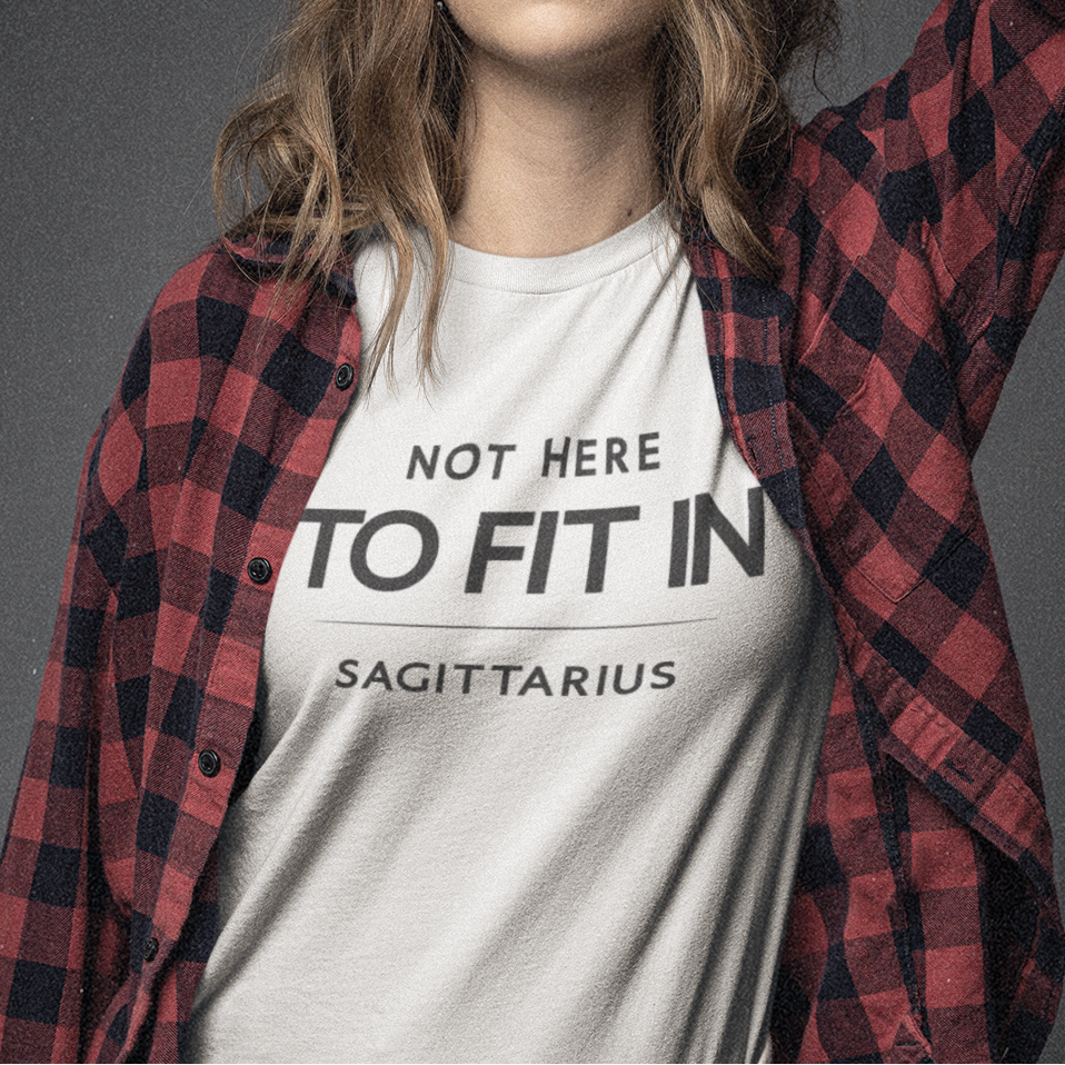 Model wearing Sagittarius zodiac t-shirt with “Not Here to Fit In” typography quote design