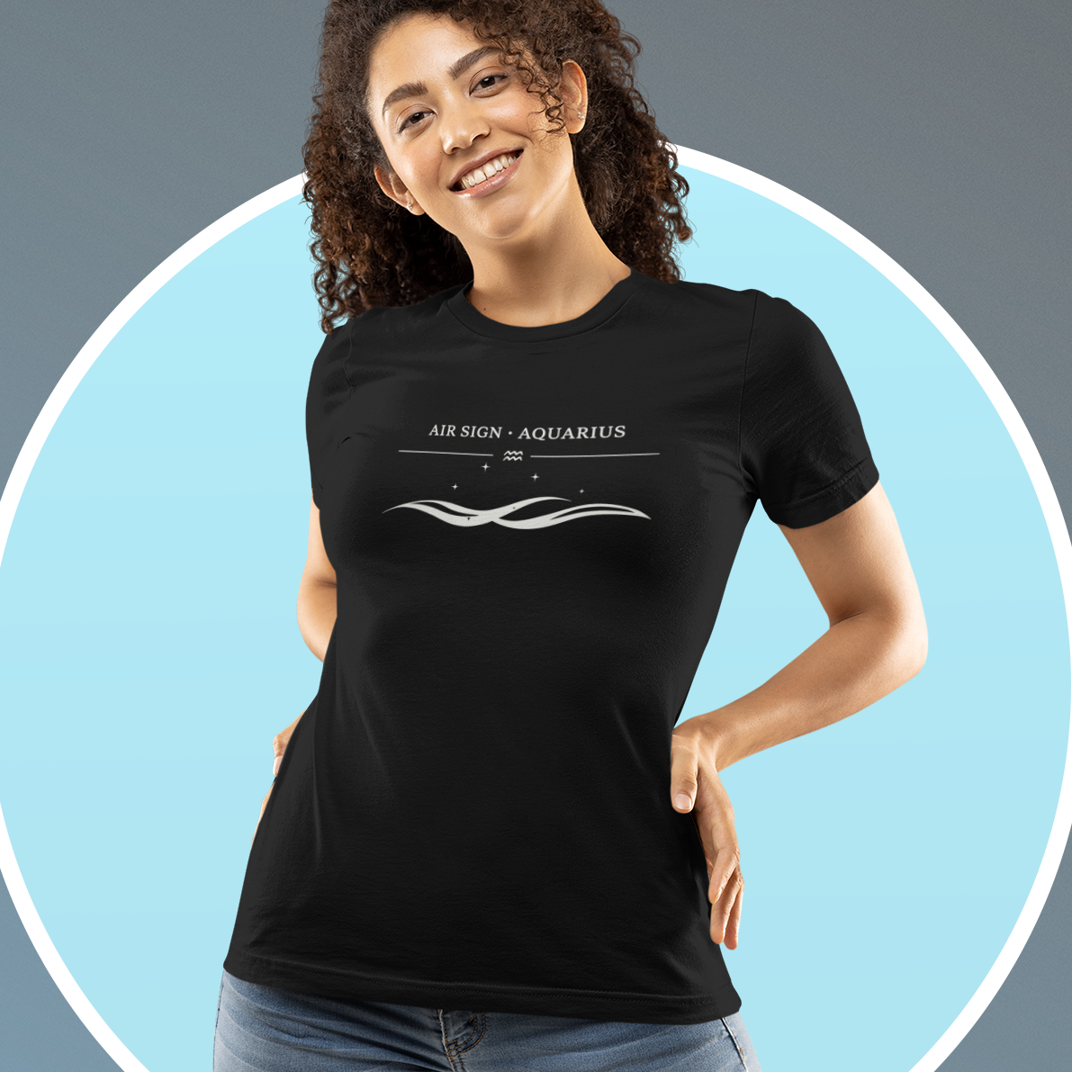 A young woman wearing a black T-shirt with a white “Air Sign · Aquarius” design featuring a minimalist wave graphic. Soft blue circular background behind her.