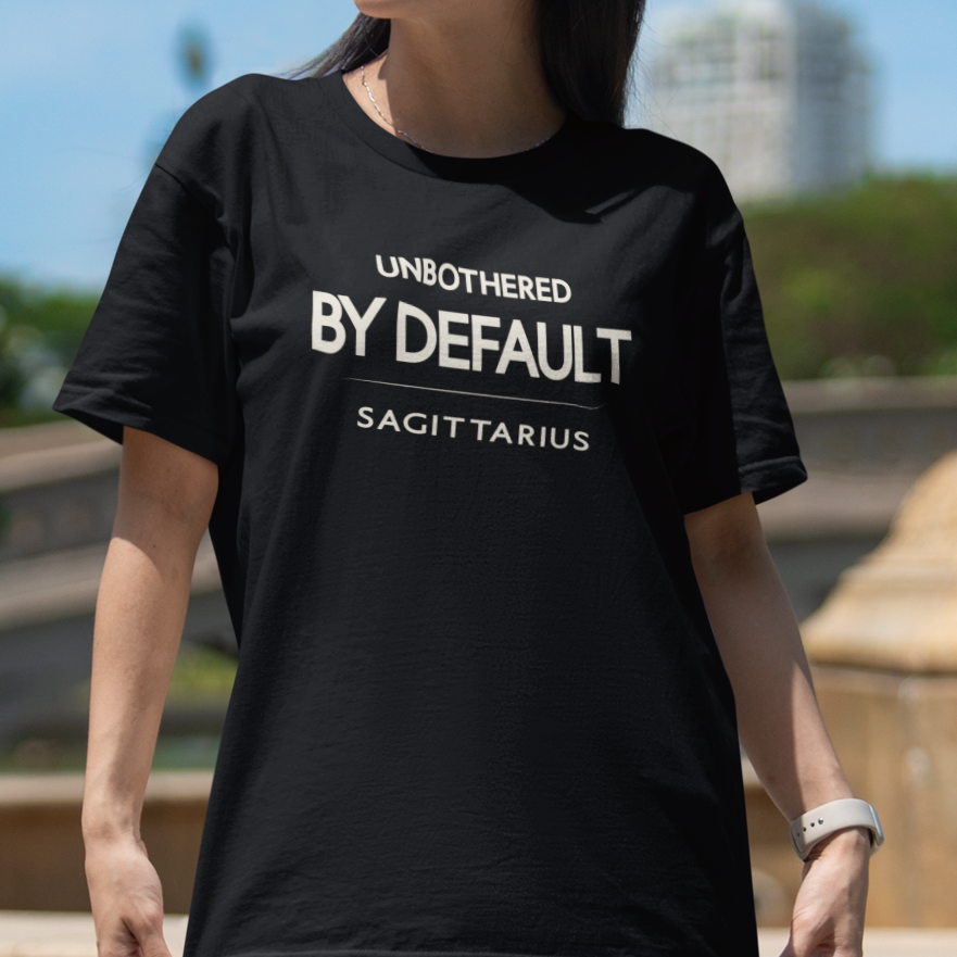 Model wearing Sagittarius zodiac t-shirt with “Unbothered by Default” typography quote design