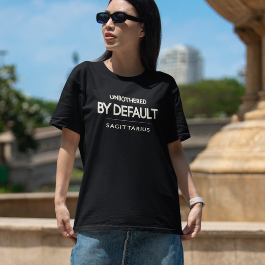 Model wearing Sagittarius zodiac t-shirt with “Unbothered by Default” typography quote design