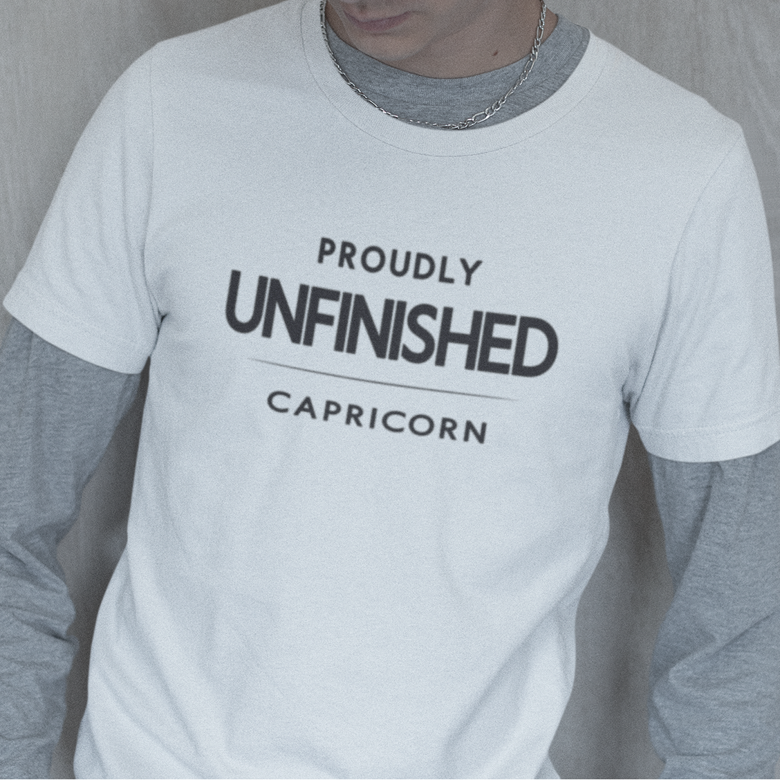 Model wearing Capricorn zodiac t-shirt with “Proudly Unfinished” typography quote design