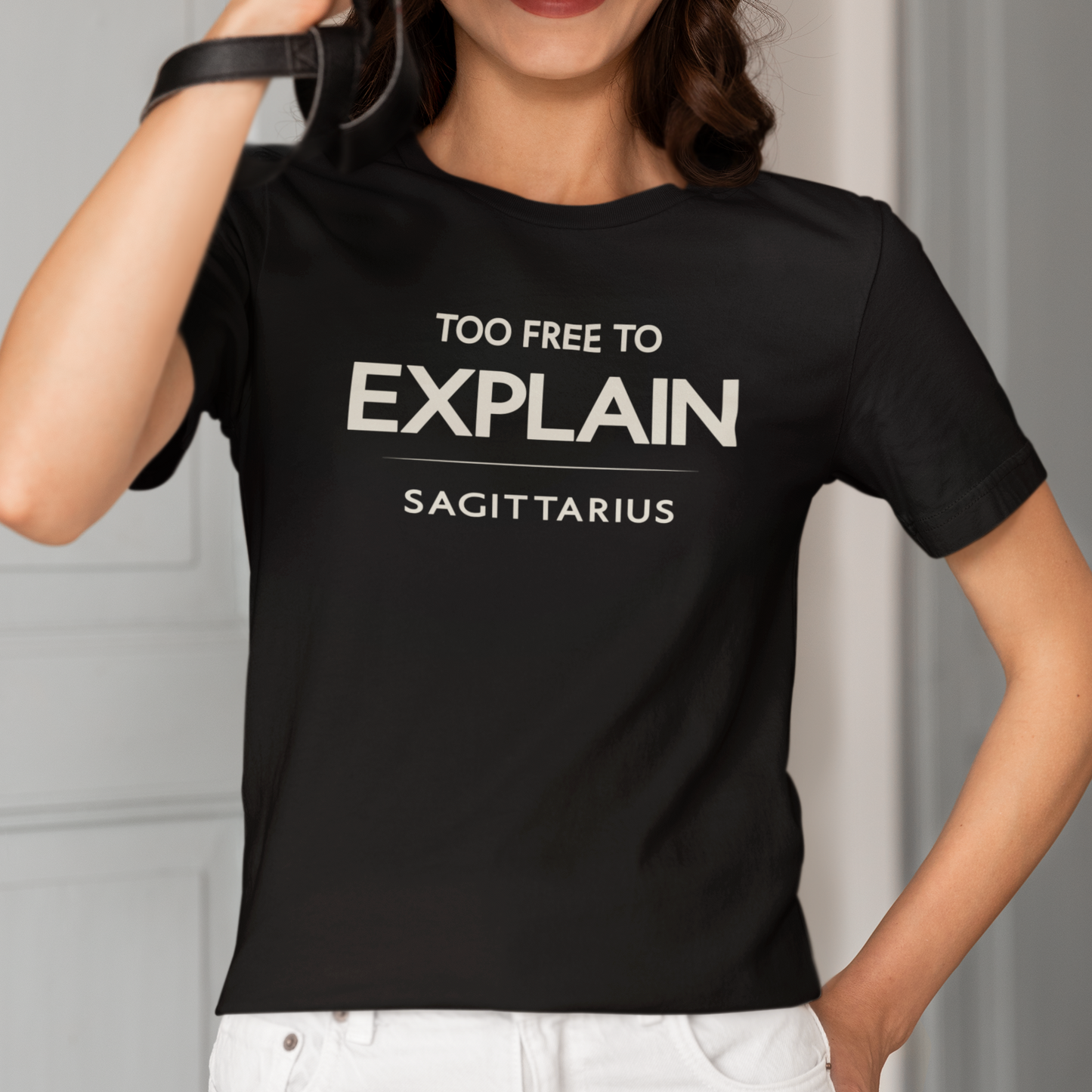 Model wearing Sagittarius zodiac t-shirt with “Too Free to Explain” typography quote