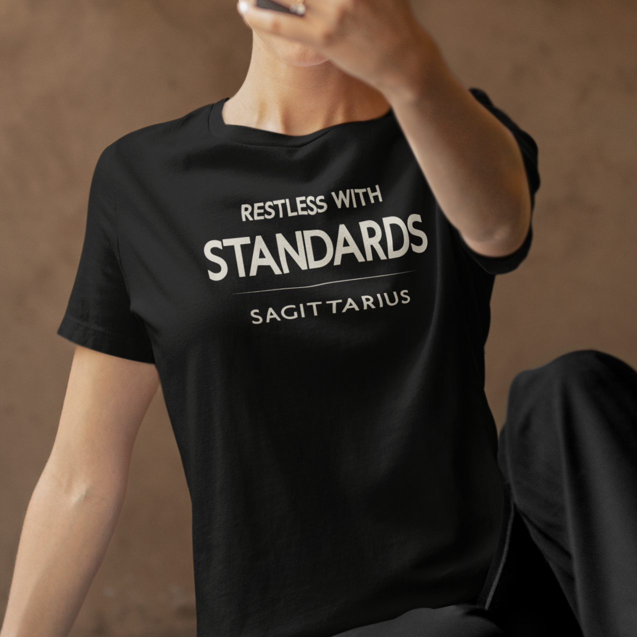 Model wearing Sagittarius zodiac t-shirt with “Restless With Standards” typography quote