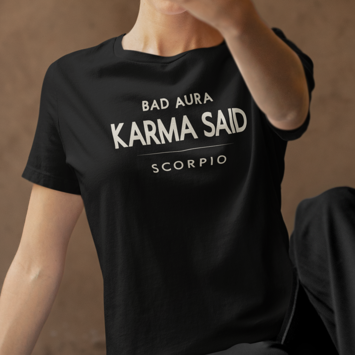 Model wearing Scorpio zodiac t-shirt with “Bad Aura Karma Said” typography quote