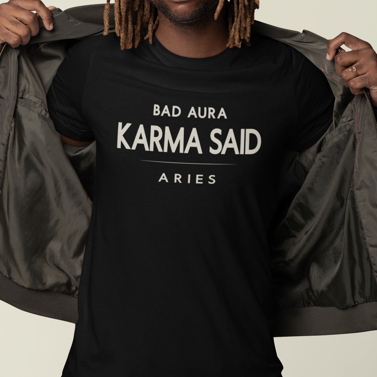 Model wearing Aries zodiac t-shirt with “Bad Aura Karma Said” typography quote