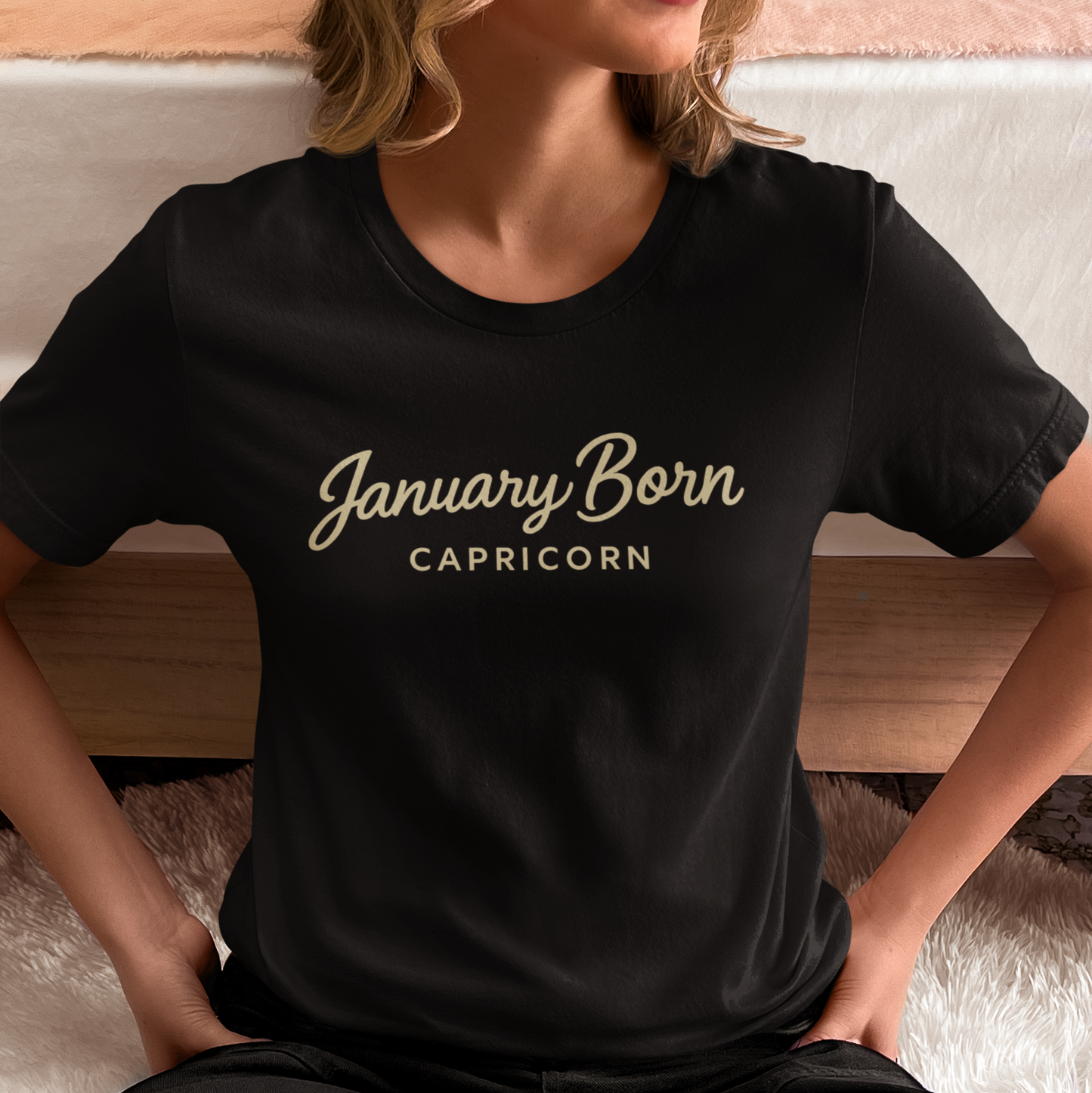 Woman wearing a black “January Born Capricorn” zodiac T-shirt in a relaxed lifestyle setting.