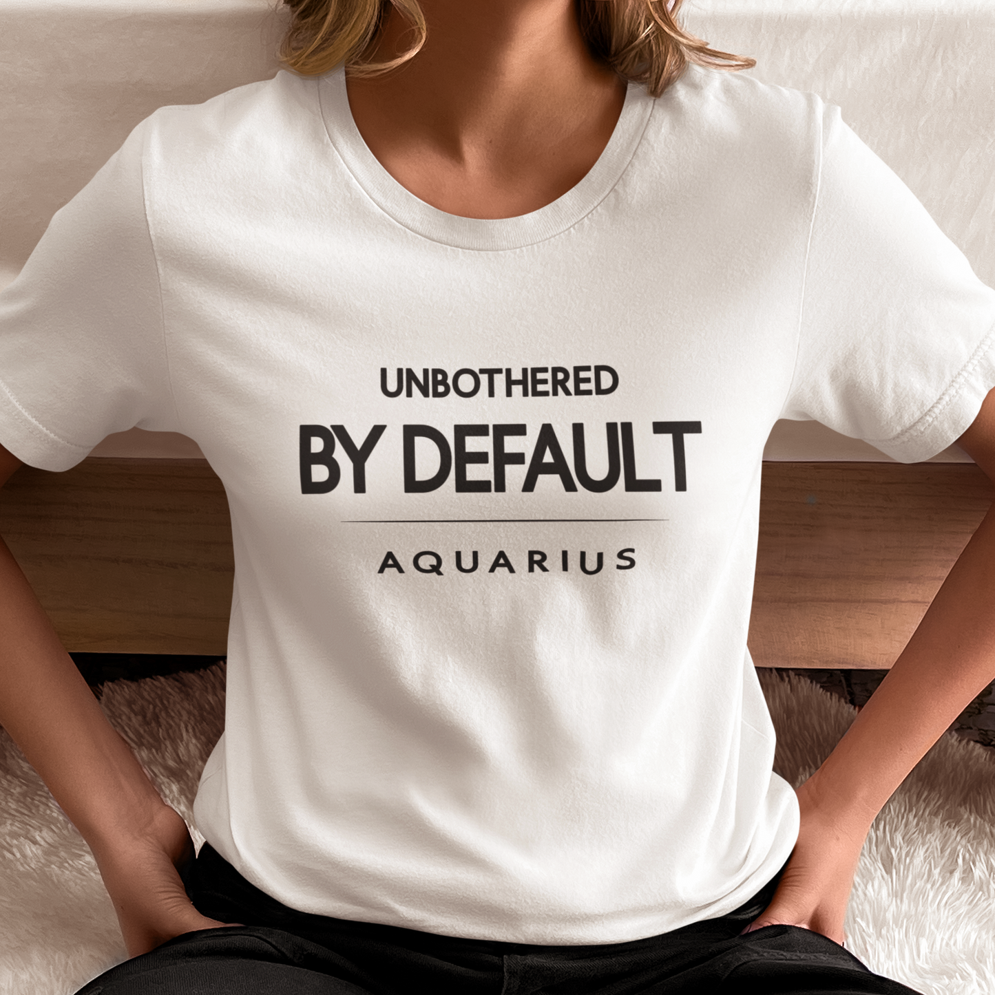 Model wearing Aquarius zodiac t-shirt with “Unbothered By Default” typography quote design