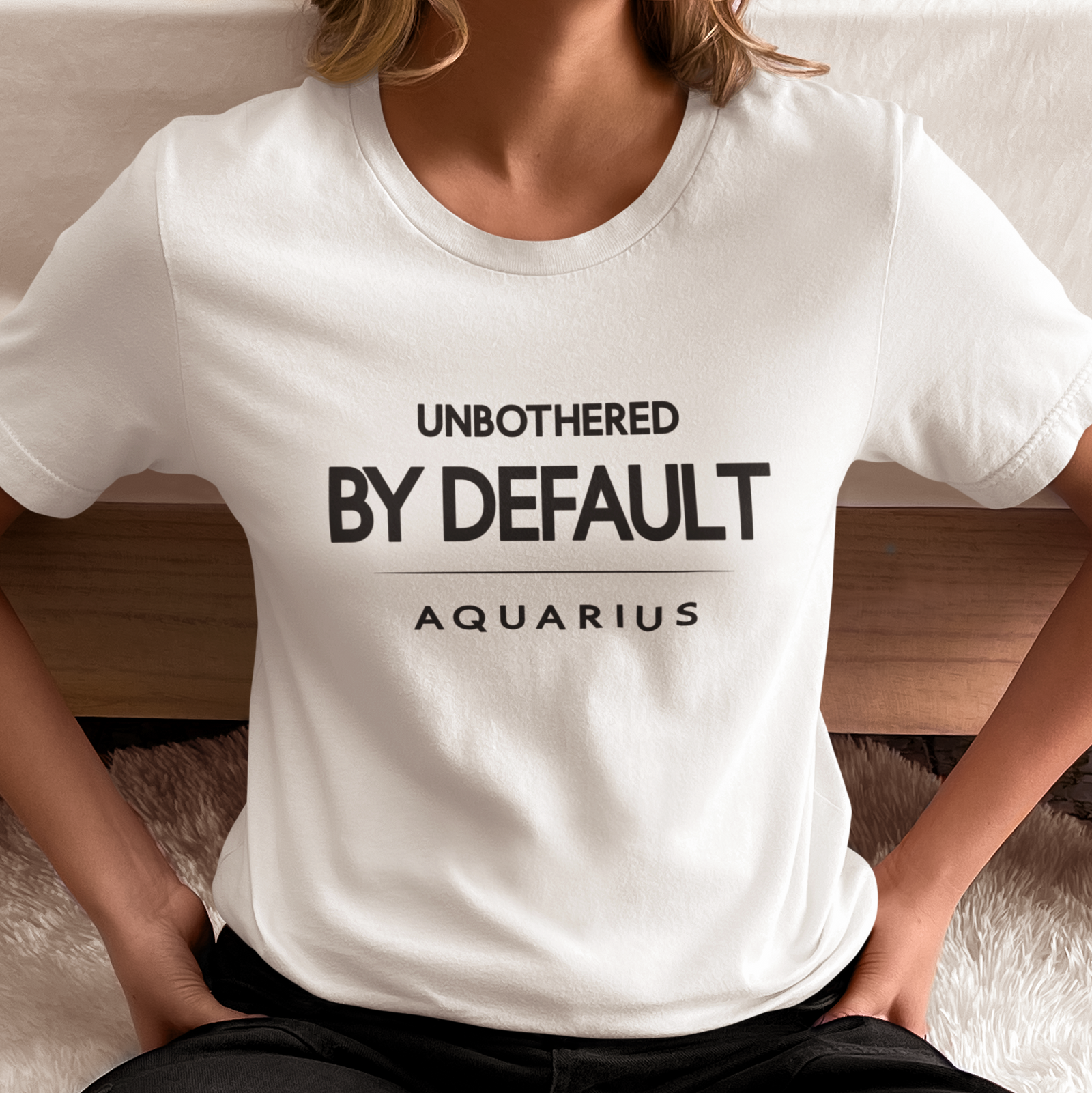 Model wearing Aquarius zodiac t-shirt with “Unbothered By Default” typography quote design
