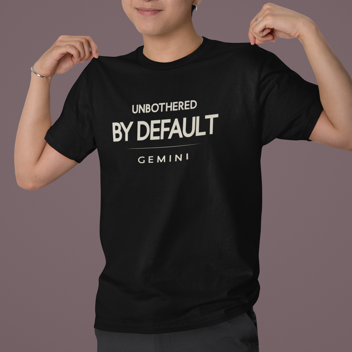 Model wearing Gemini zodiac t-shirt with “Unbothered By Default” typography quote design