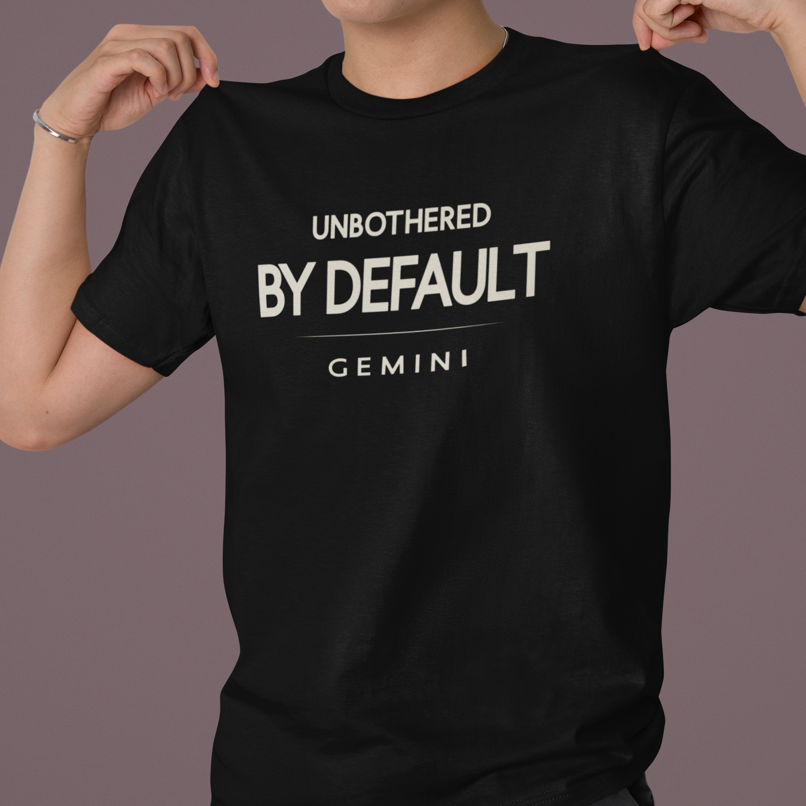 Model wearing Gemini zodiac t-shirt with “Unbothered By Default” typography quote design
