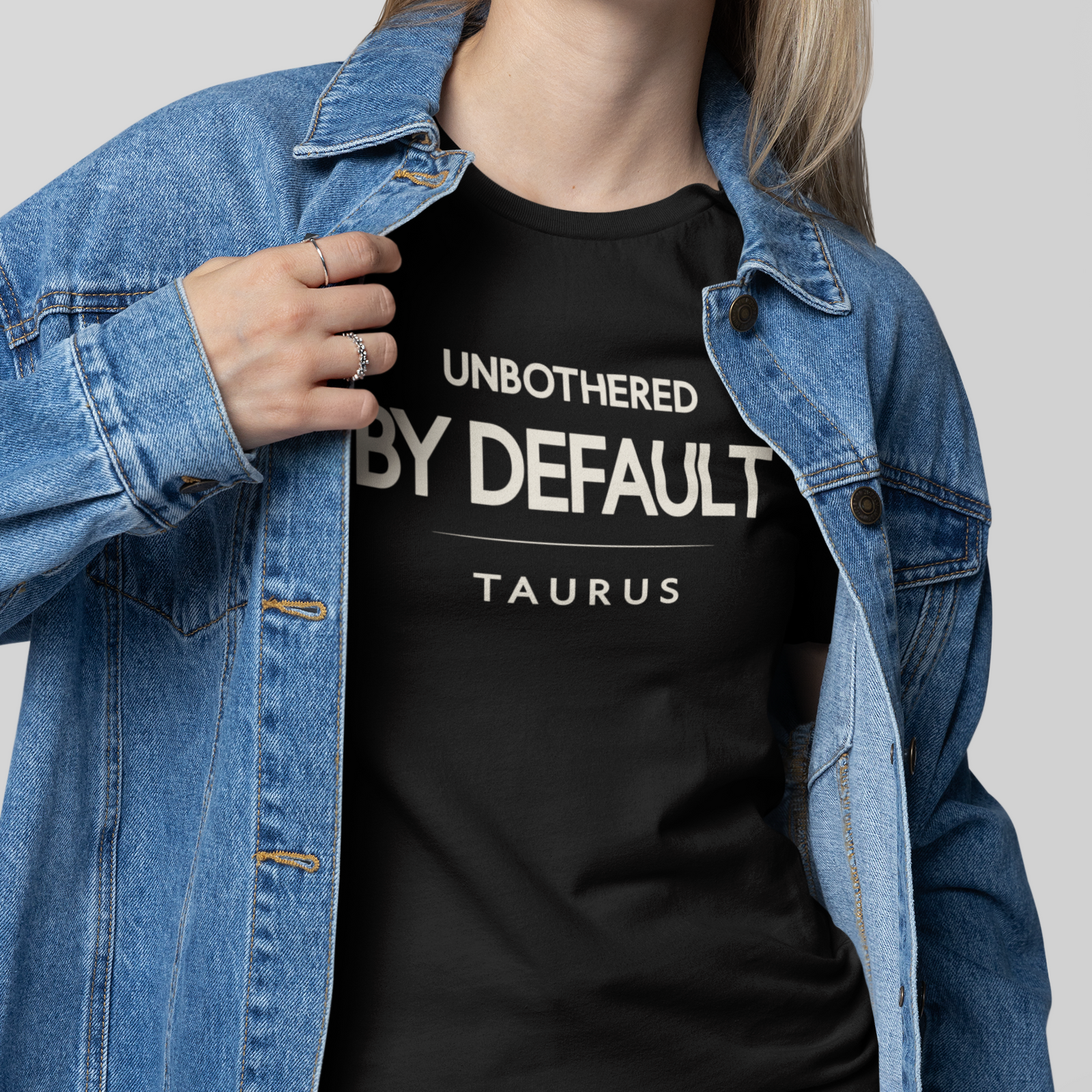 Model wearing Taurus zodiac t-shirt with “Unbothered by Default” typography quote