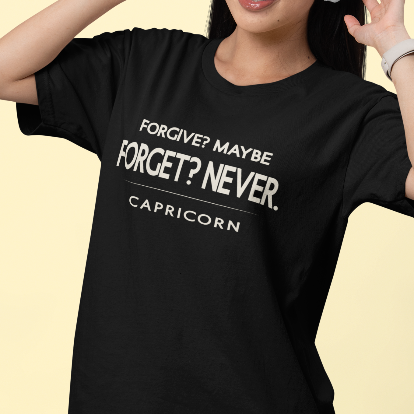 Model wearing Capricorn zodiac t-shirt with “Forgive? Maybe – Forget? Never” typography quote design