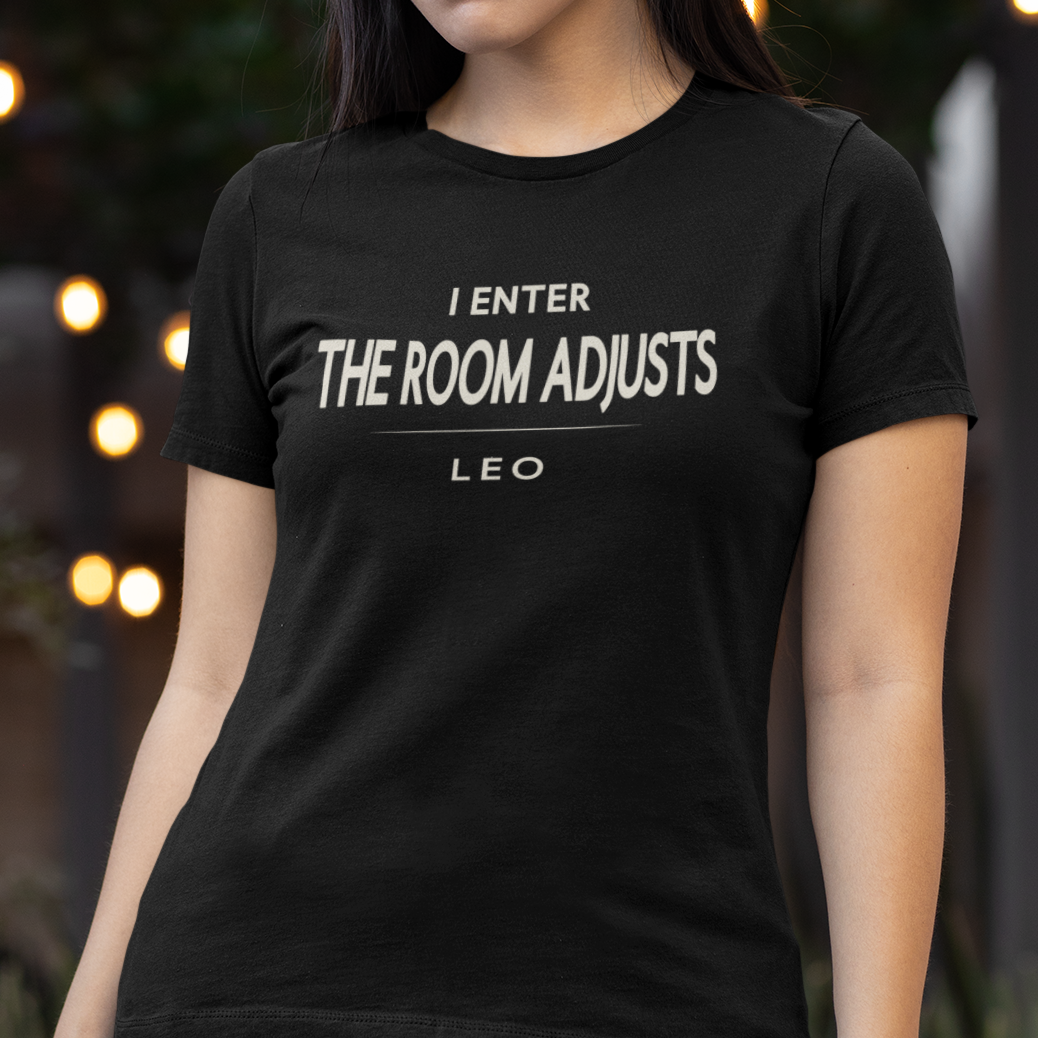 Model wearing Leo zodiac t-shirt with bold “I Enter The Room Adjusts” typography quote