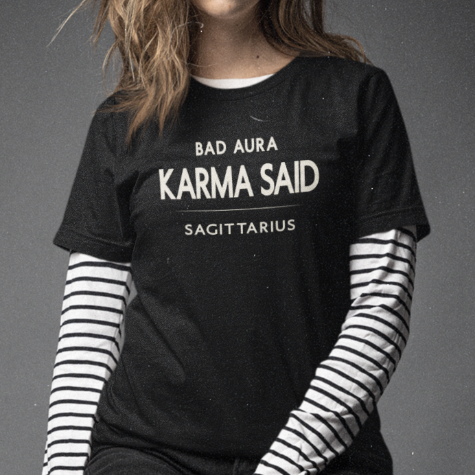 Model wearing Sagittarius zodiac t-shirt with “Bad Aura Karma Said” typography quote
